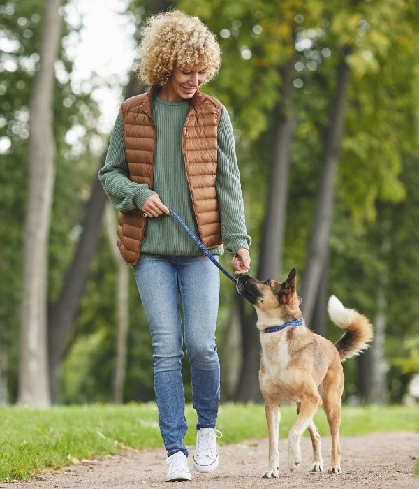 A woman relaxing on a walk with her dog after getting TMS therapy in Colorado Springs at The Mind Grove TMS Treatment Center