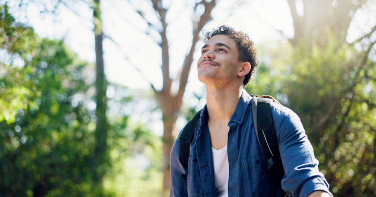 Man pausing on a forest trail in thought, TMS for PTSD research and off-label treatment options